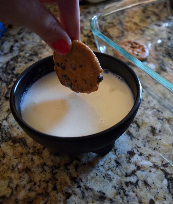 Dunk the cookies in milk, then layer in the dish to create the first layer of this cookie dough dessert.