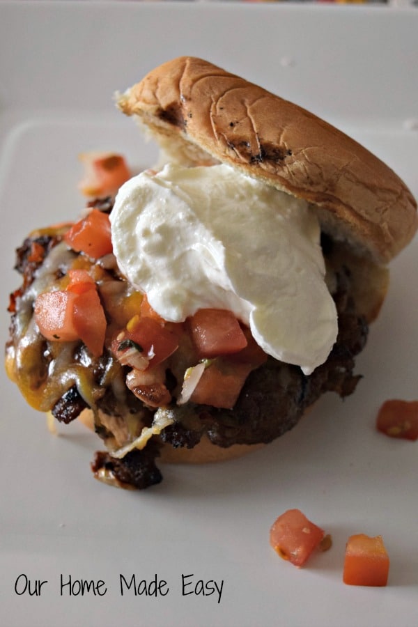 Super easy and yummy taco burger sliders topped with sour cream and diced tomatoes