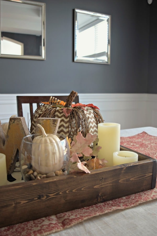 A diy fall themed table centerpiece with a fabric table runner