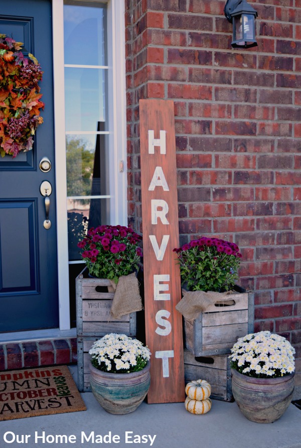 decorating your front porch is all about the small details like rustic wood signs and flowers