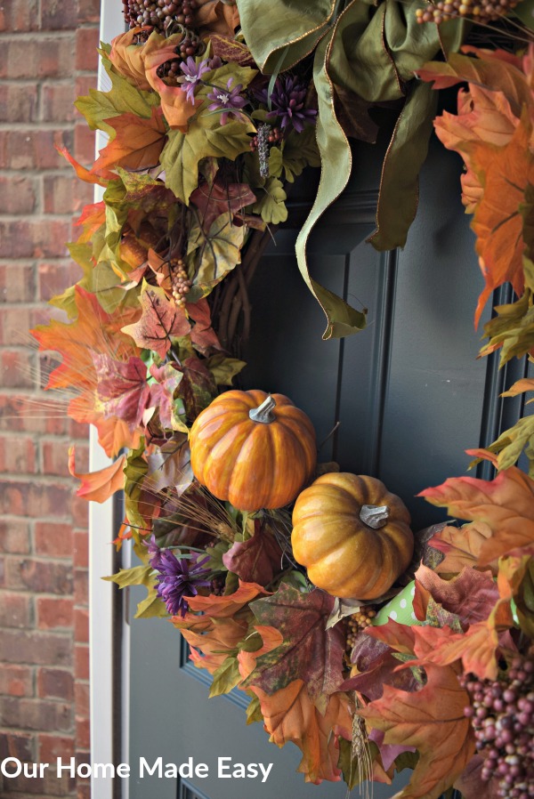 This fall wreath is packed with colorful leaves, ribbons, and pumpkins