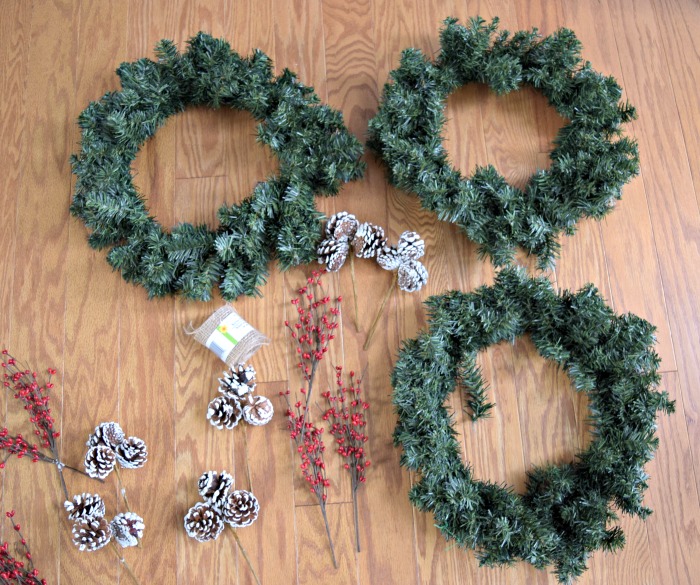 To make this super easy DIY Christmas wreath, all you need are some decorative picks like holly berries or pinecones, and a plain wreath