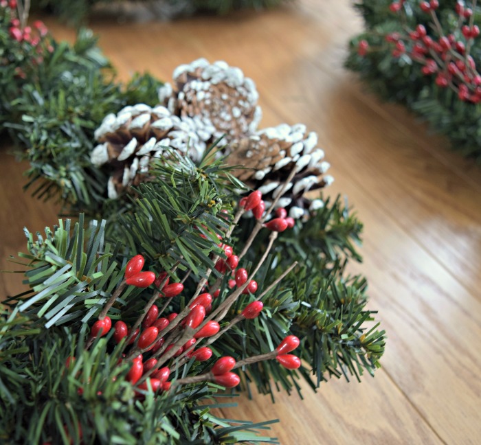 I love how easy it is to add fun seasonal accents to a Christmas wreath, like holly berries and frosted pine cones