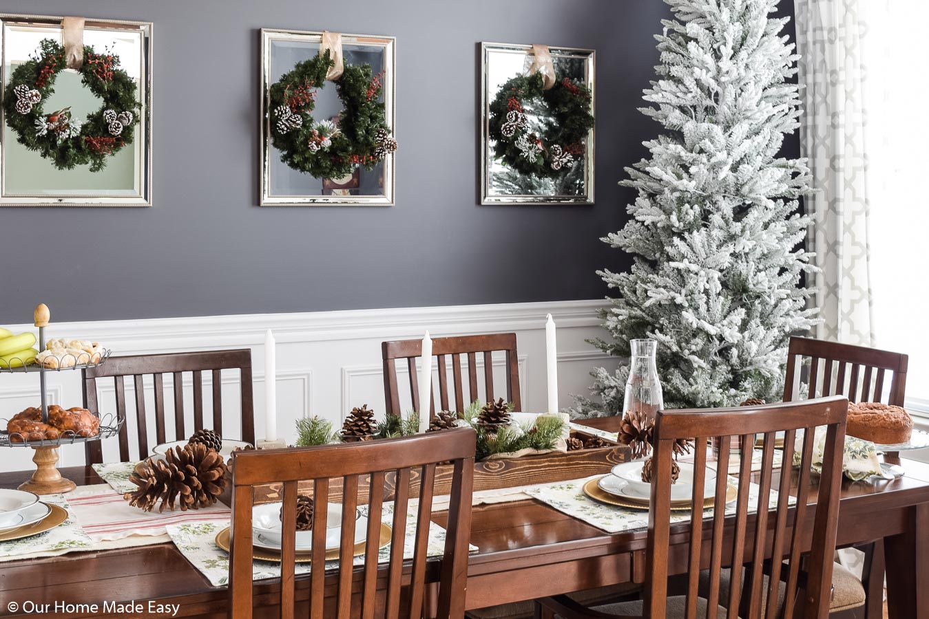 Our Christmas dining room is simple and bright, with a faux white-frosted Christmas tree, wreaths, and festive place settings