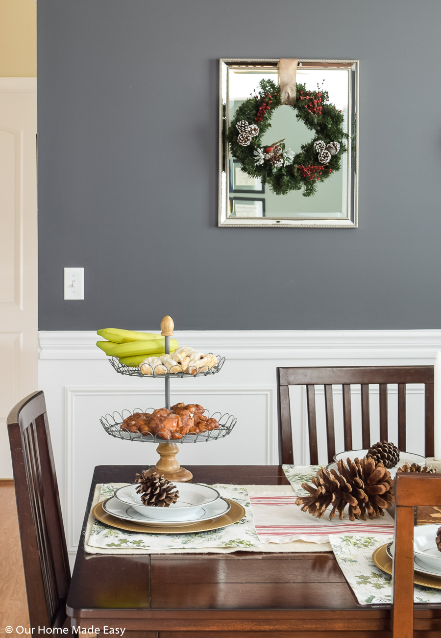 A two tiered pastry try sits on the corner of our dining room table, with a Christmas fir wreath in the background