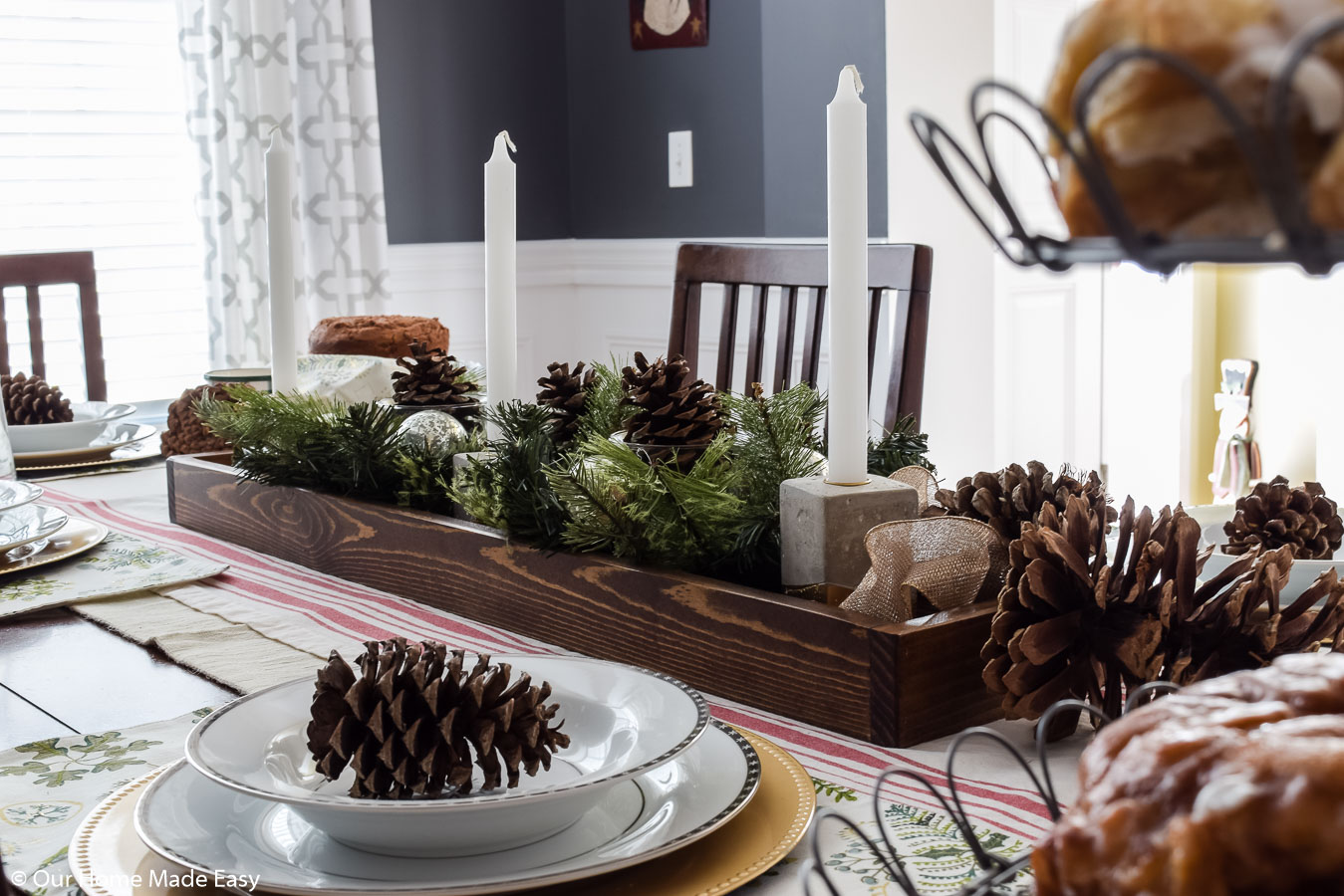 This simple DIY wood tray is perfect for centerpieces. We made a Christmas centerpiece with pinecones and faux fir branches