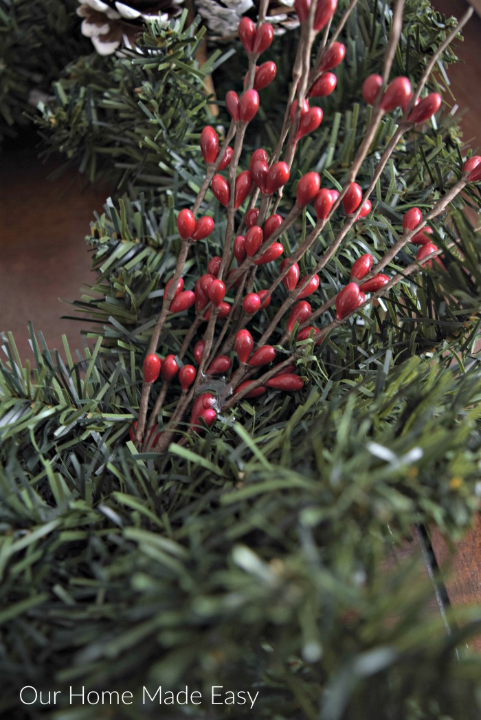 Holiday picks like this bunch of faux holly berries can easily be attached to your wreath with floral wire