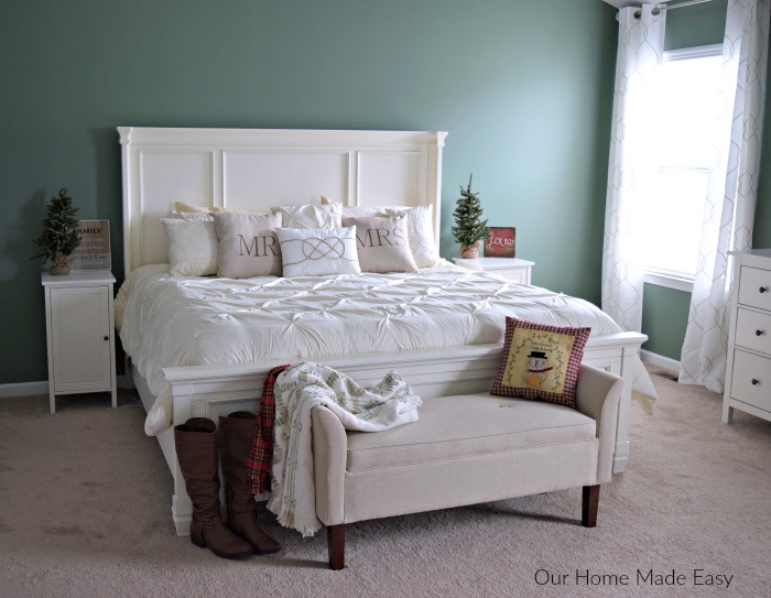 Master bedroom bed with Christmas decorations, mini pine trees on the night stands, and Christmas pillows