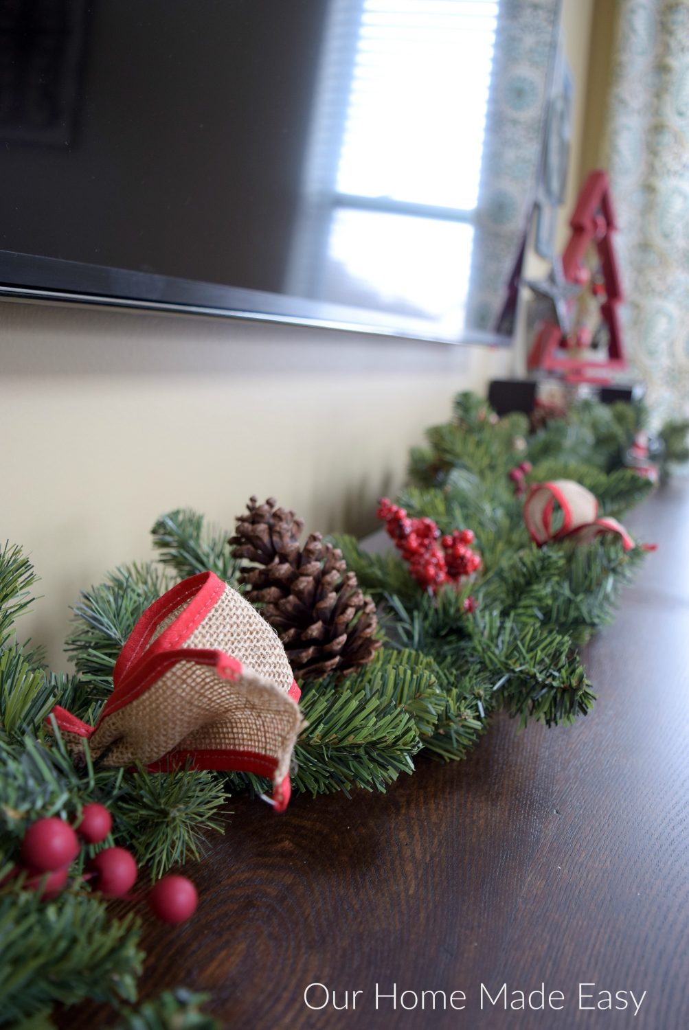 This faux pine garland with burlap ribbon and pinecones is a simple way to add a festive Christmas touch to your home.