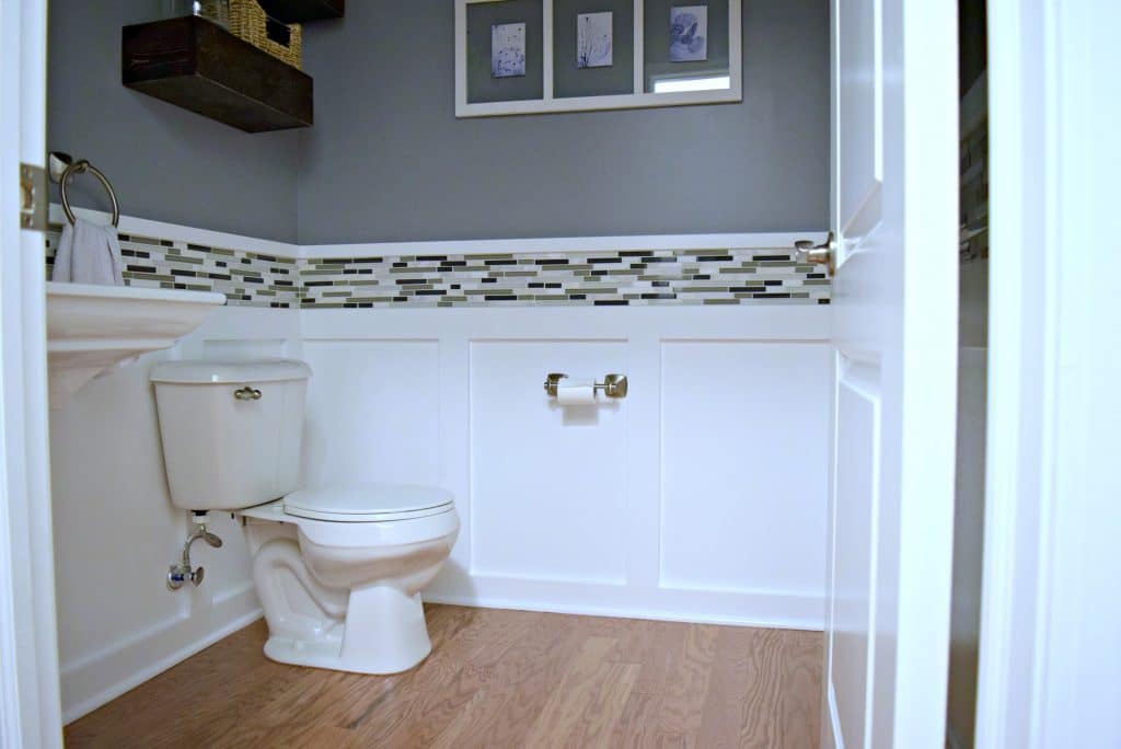 Here is an easy DIY budget powder room makeover! We used easy projects to go from builder grade to modern. Click to see how we did it!