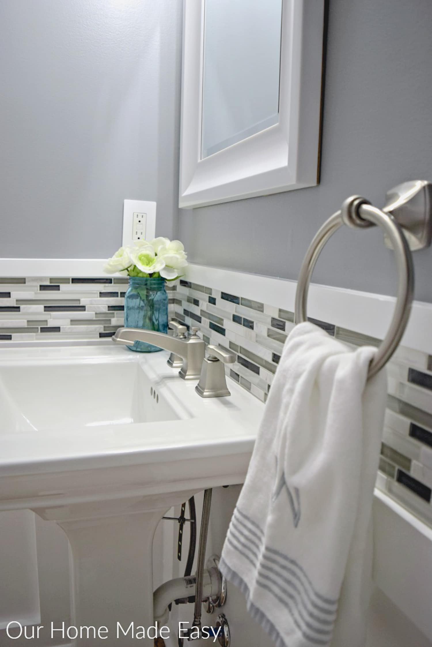 Our DIY budget powder room makeover turned out great - we live this tile backsplash with the new paint color