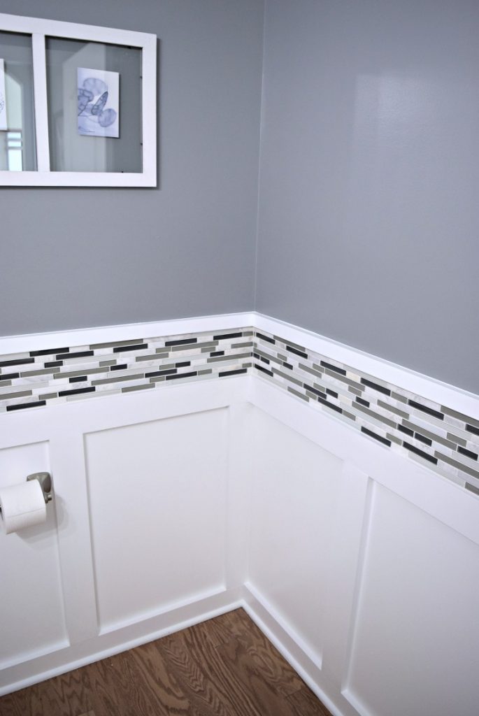 Batten board walls with a new black, white, and gray tile border and soft gray paint