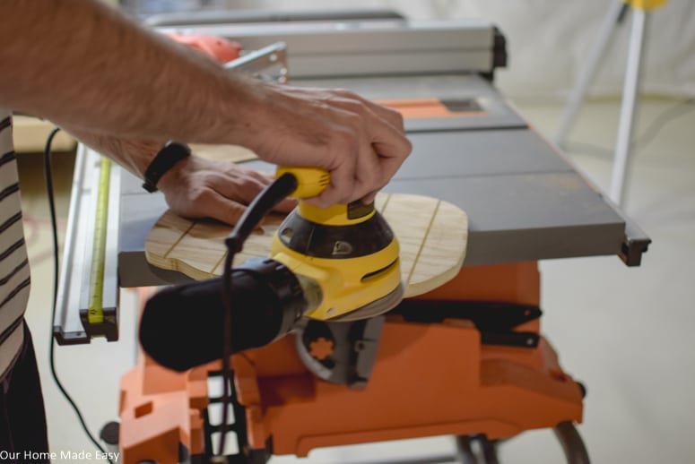 Use an orbital sander to sand down and smooth out the surface and sides of the plywood pumpkin