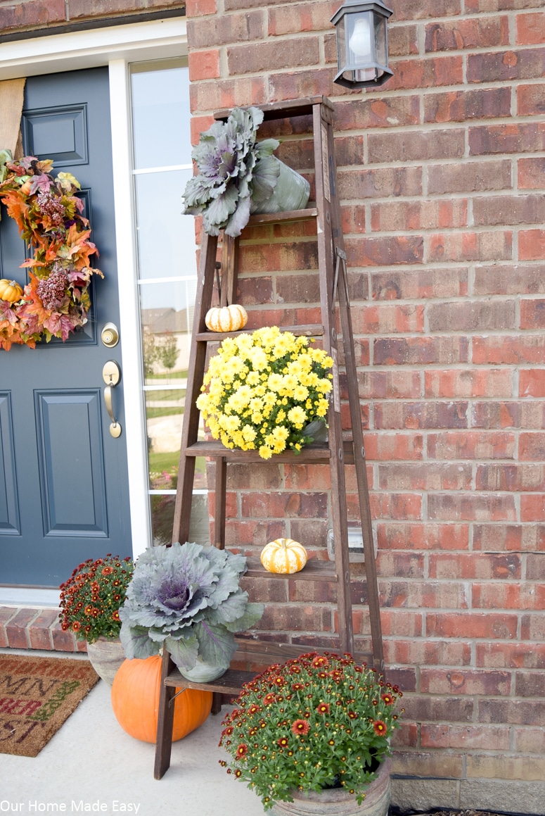 Simple rustic fall front porch with planted mums and pumpkins