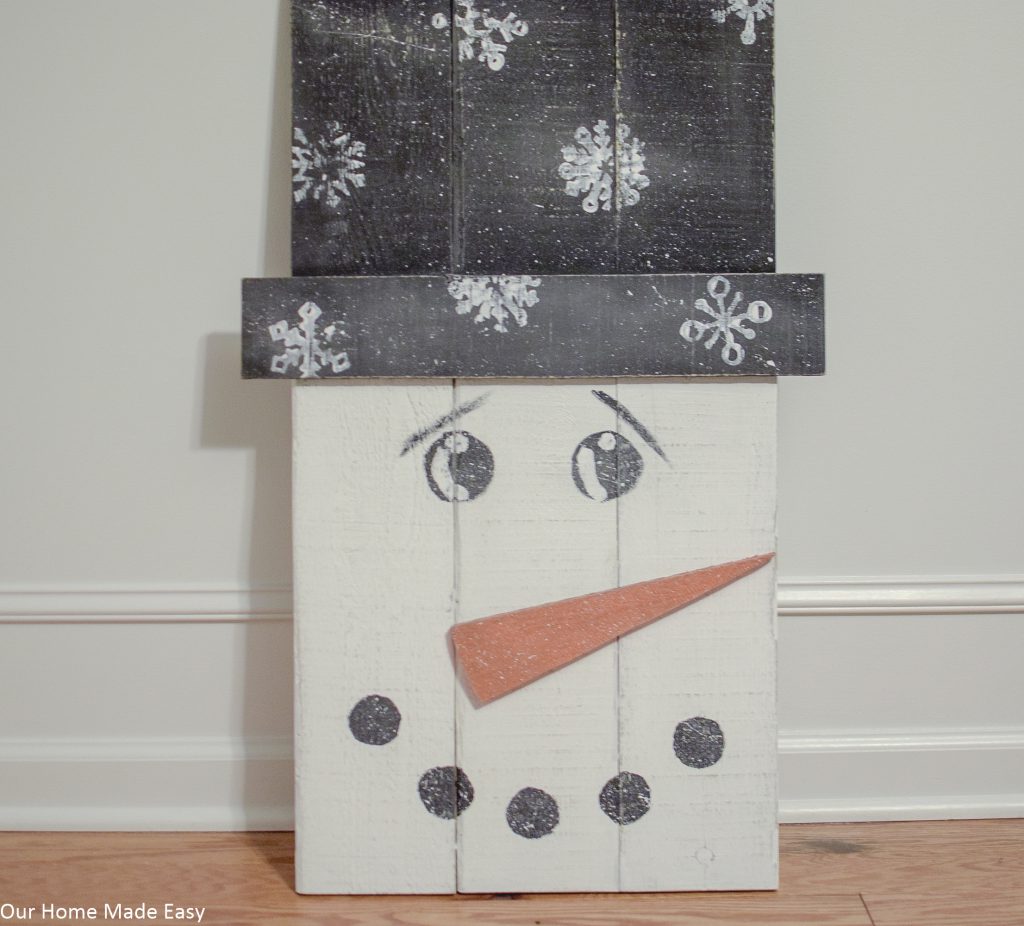 Make this super easy pallet snowman! Use some leftover paint and wood to build this easy DIY snowman. No fancy tools needed!