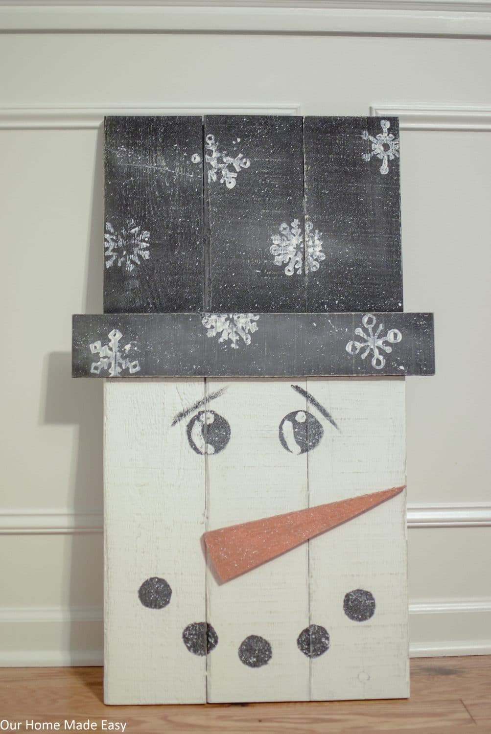 Make this super easy pallet snowman! Use some leftover paint and wood to build this easy DIY snowman. No fancy tools needed!