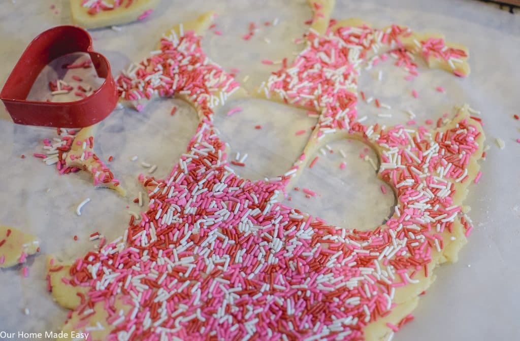 Cover the rolled out dough in festive Valentine's sprinkles and cut out heart-shaped cookies