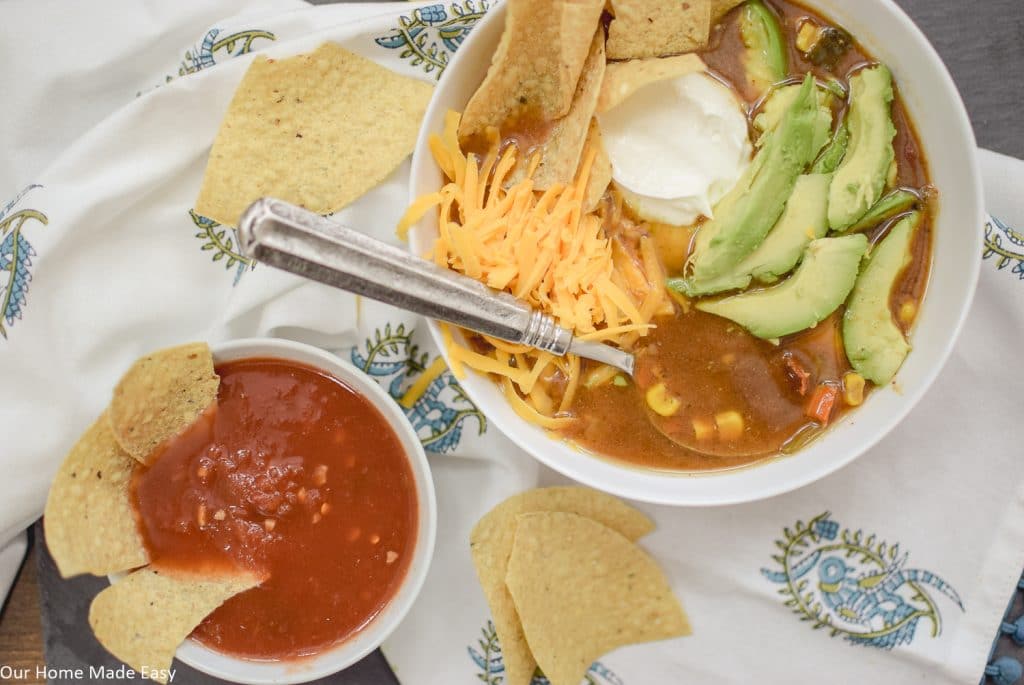 Serve this delicious slow cooker tortilla soup with some shredded cheese, soup cream, avocado, and of course, chips and salsa on the side!