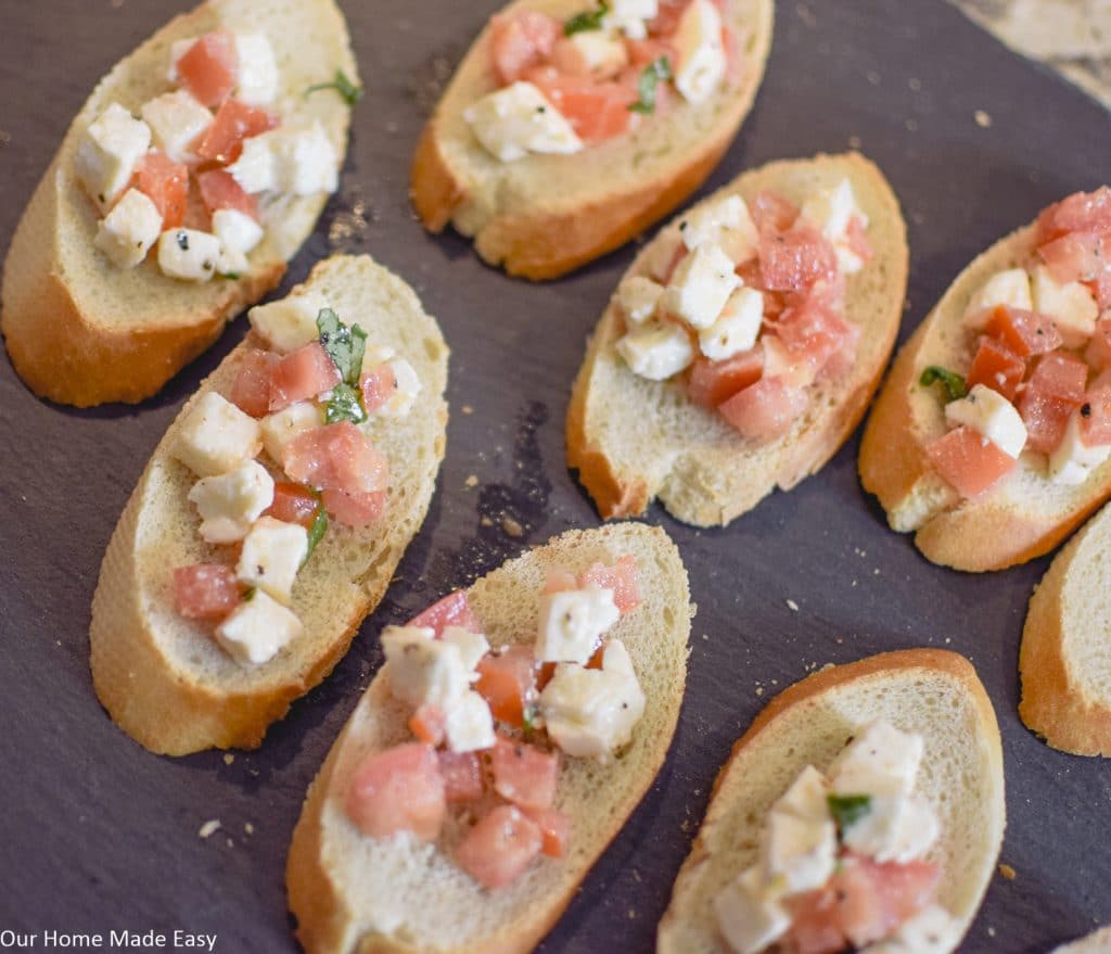 Toasted baguettes and Caprese topping with diced tomatoes, mozzarella and basil