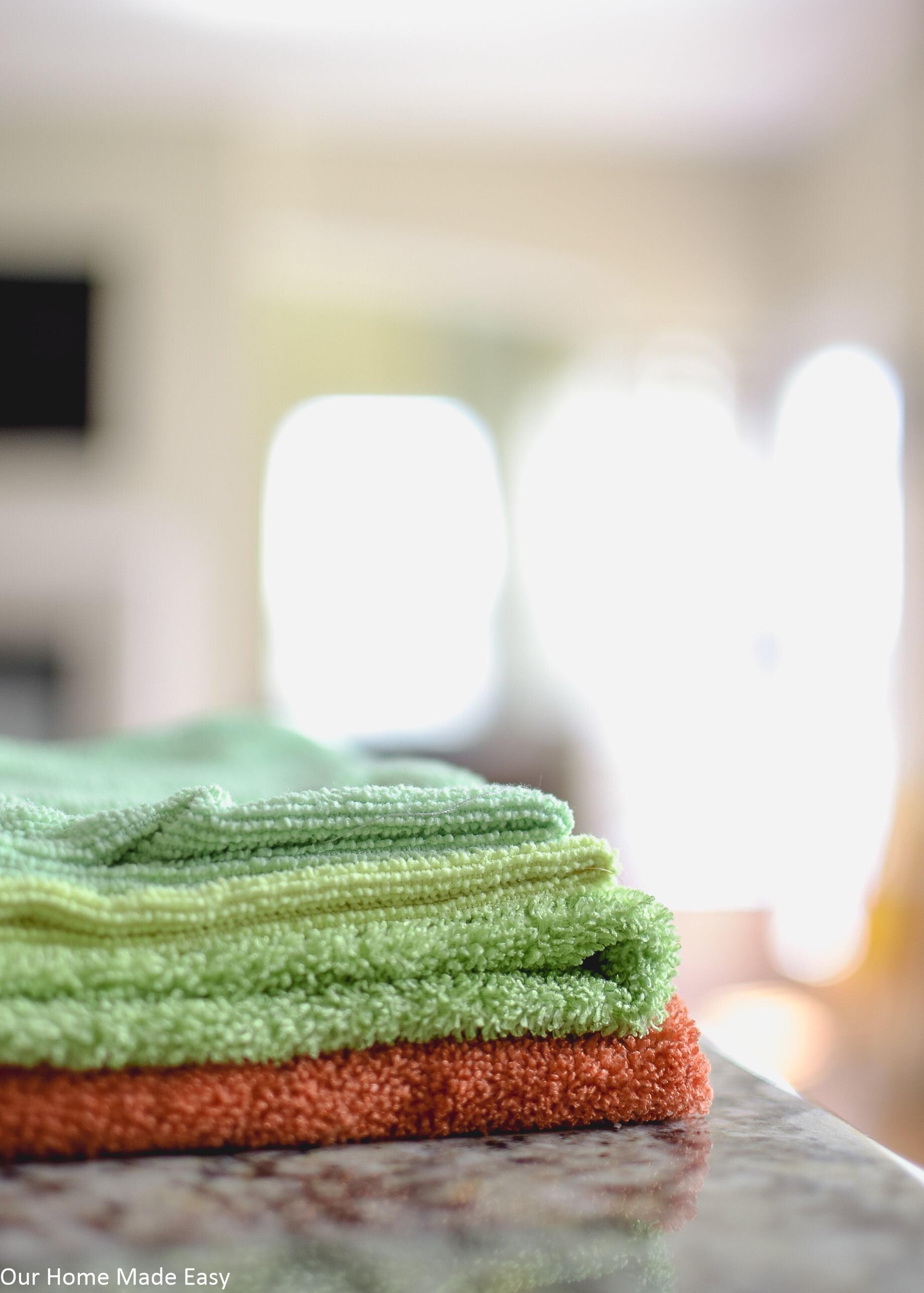 Folded microfiber towels in orange, green, yellow, and blue