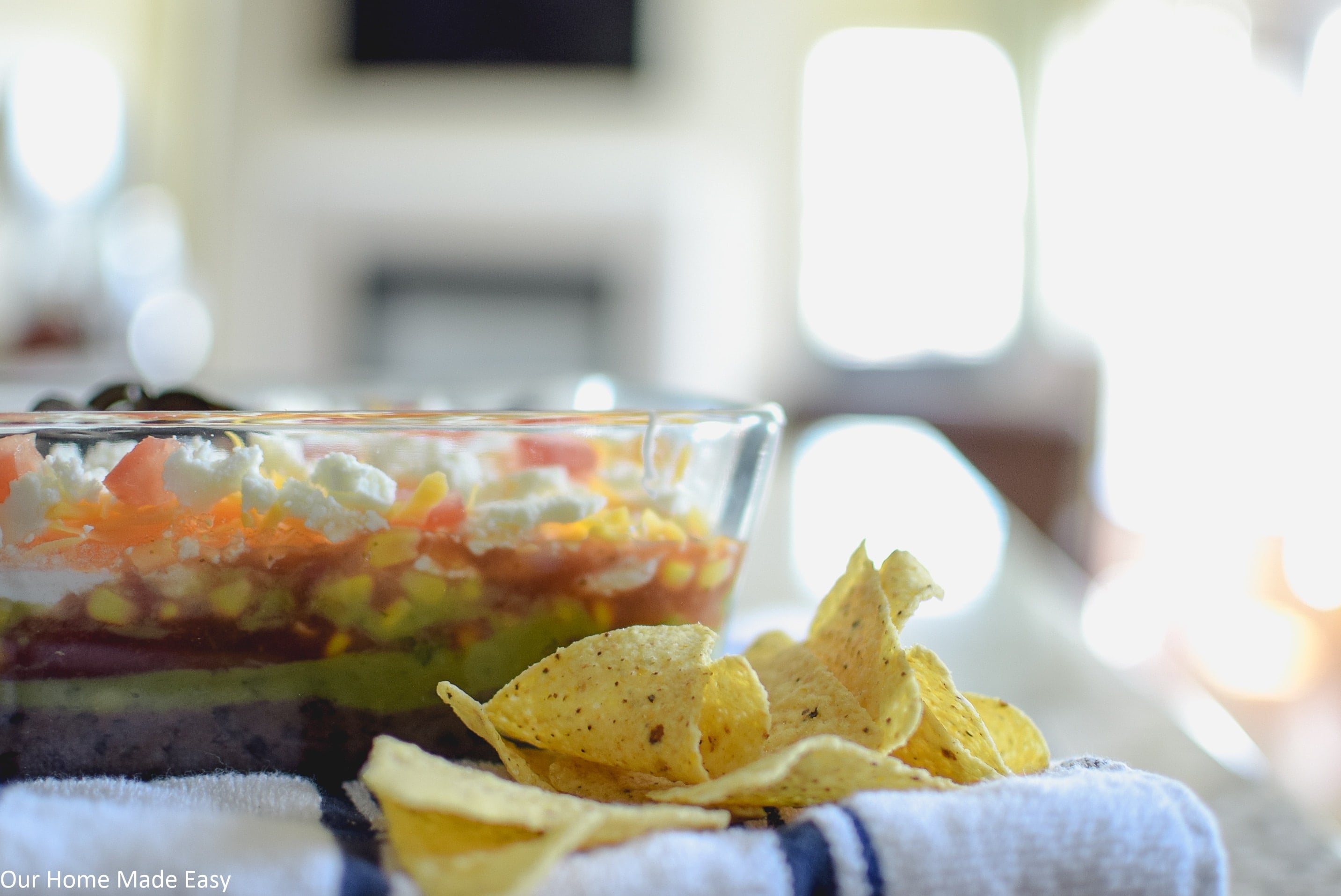 serve this 7 layer taco dip with chips for a delicious party appetizer