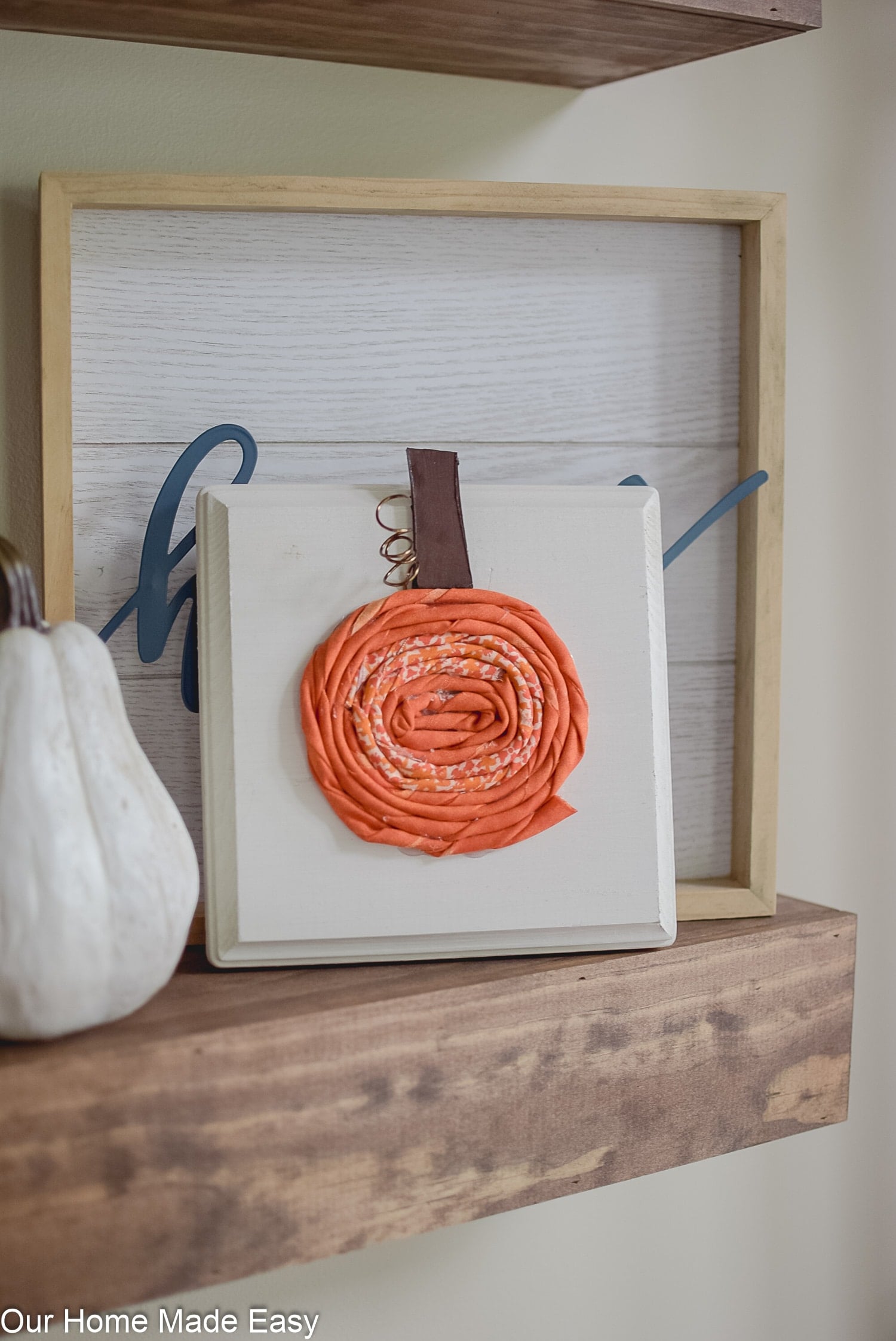 Here's how to make these cute fabric pumpkins on simple wood boards