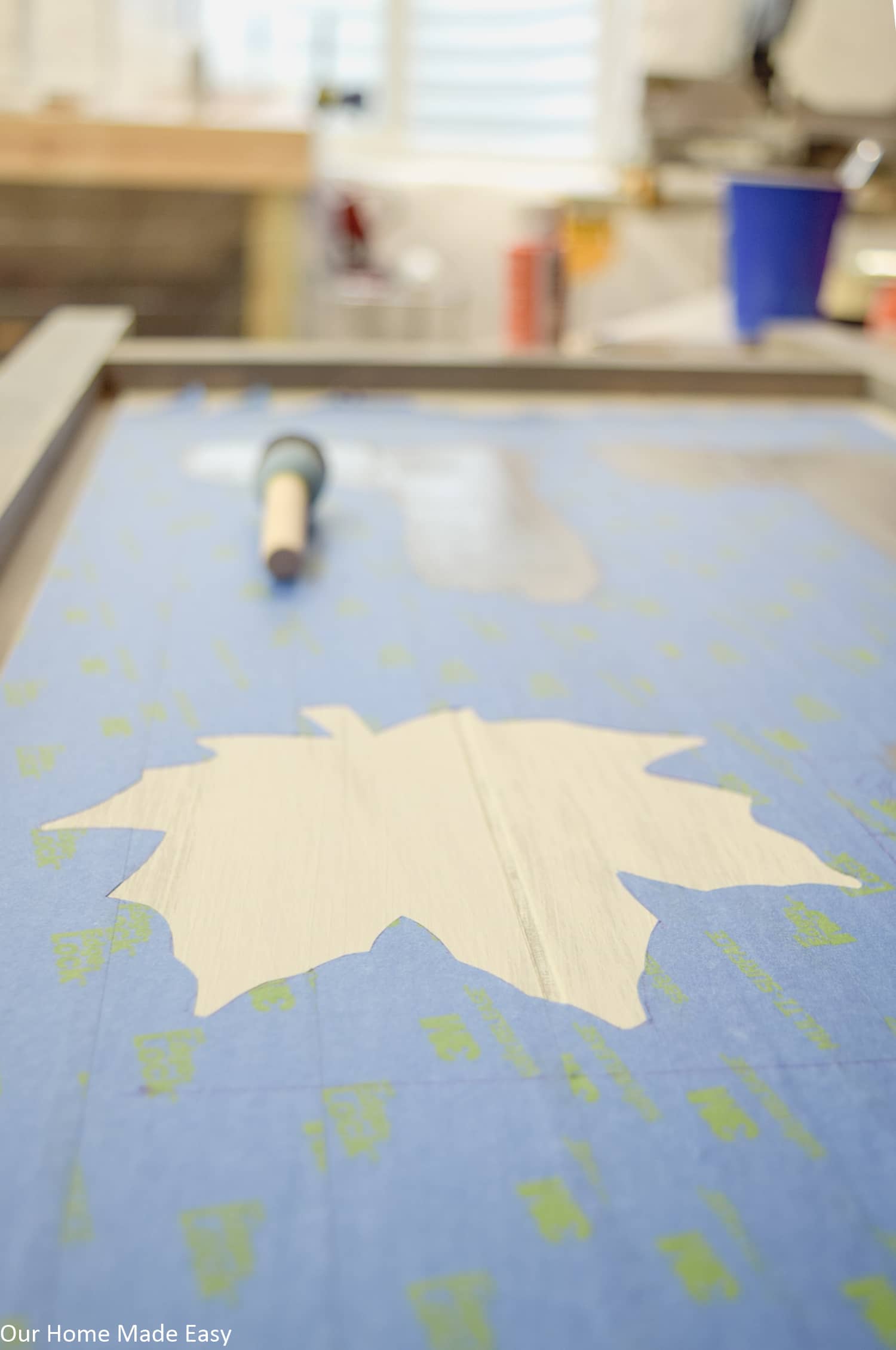 To decorate our Fall wood sign, we used painters tape and an exacto knife to cut out this maple leaf outline