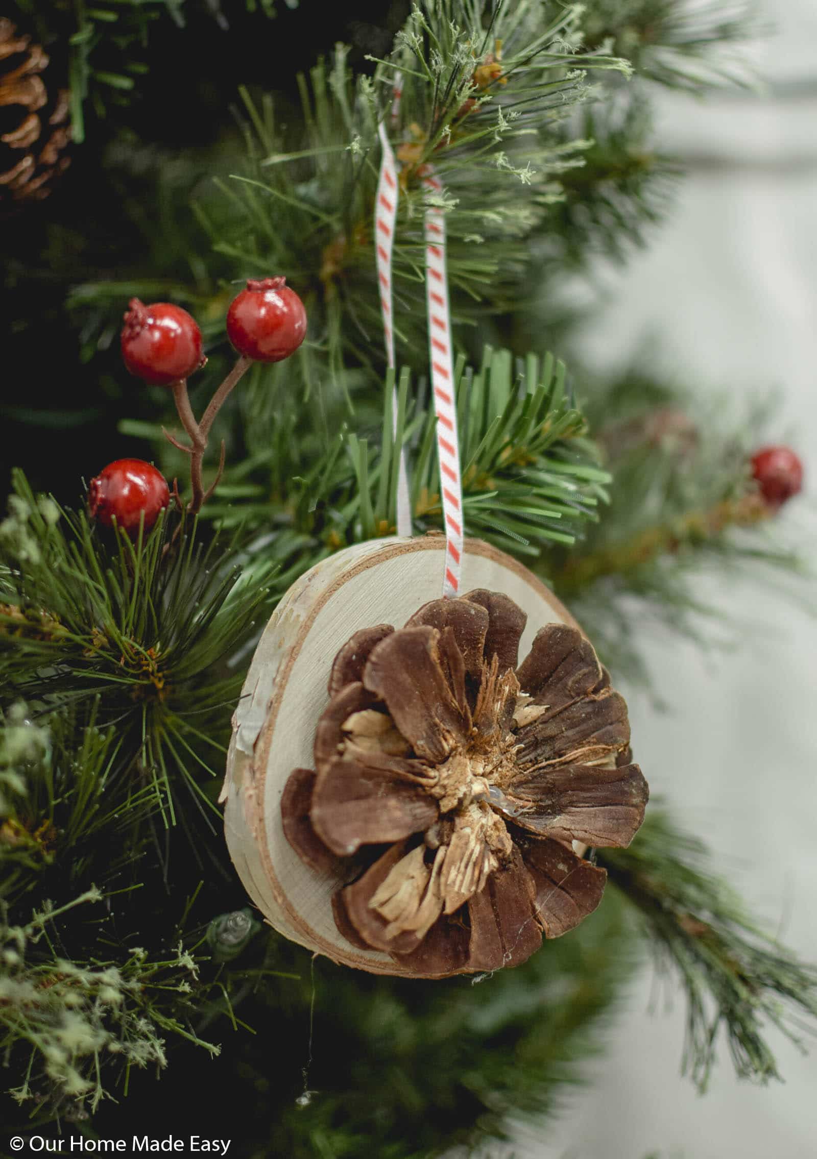 This pinecone wood slice ornament is a cute homemade Christmas ornament to gift to friends and famuly