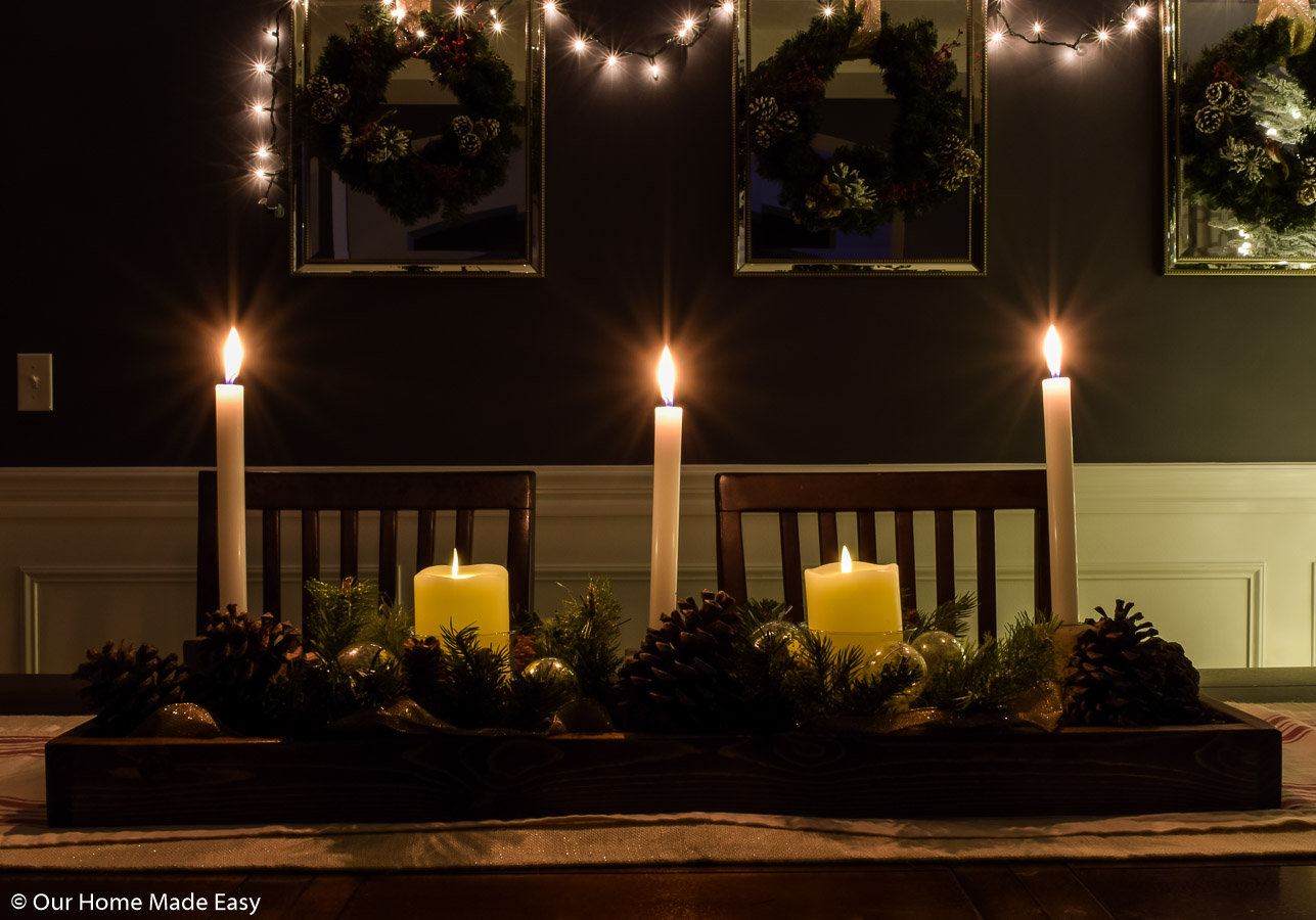 Our dining room table Christmas table centerpiece is brightened up with simple white candle sticks