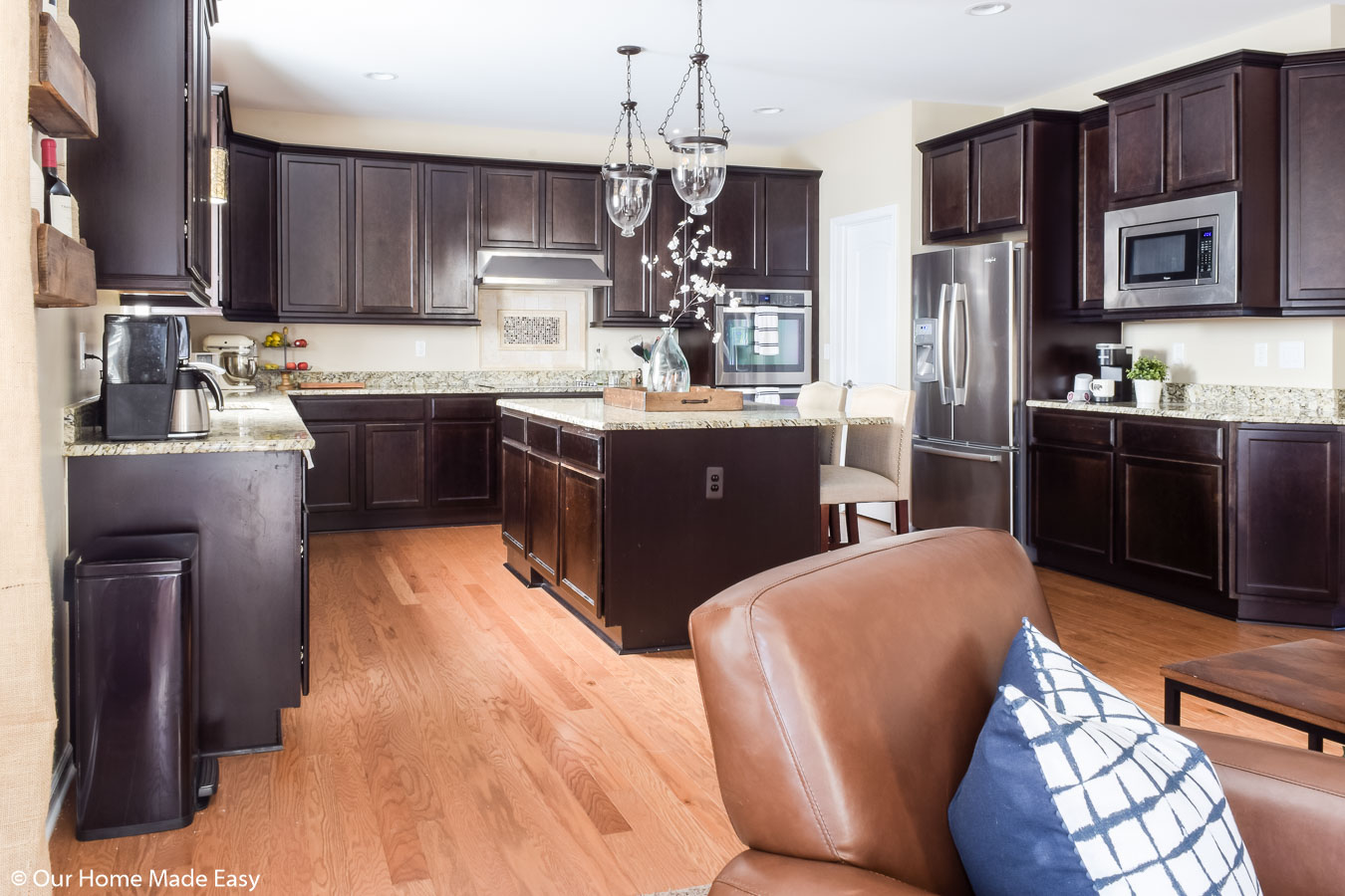 Our home kitchen with dark wood cabinets and marble counter tops