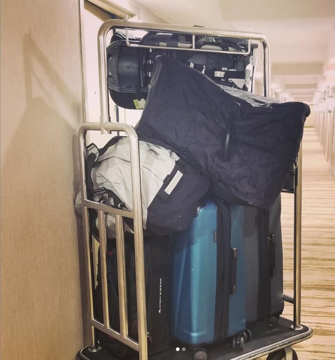 Suitcases piled high on a luggage rack in a hotel room in Phoenix