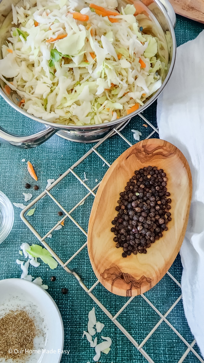 black peppercorns in wood bowl