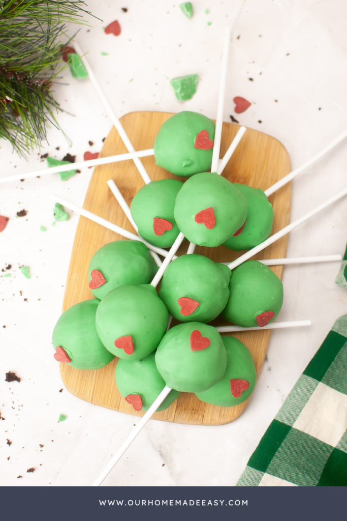 grinch cake pops on wooden cutting board