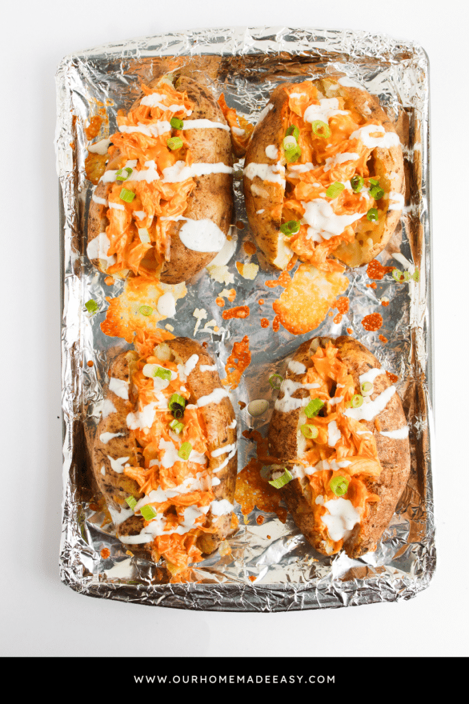 finished buffalo chicken baked potatoes on baking sheet