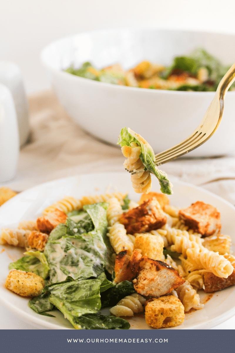 Fork holding romaine lettuce with Caesar dressing