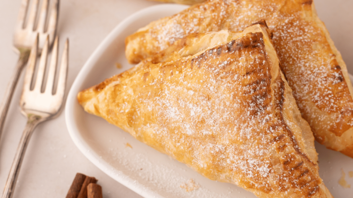 finished apple turnovers with puff pastry on white plate