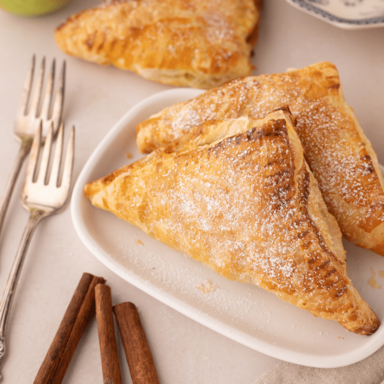 finished apple turnovers with puff pastry on white plate