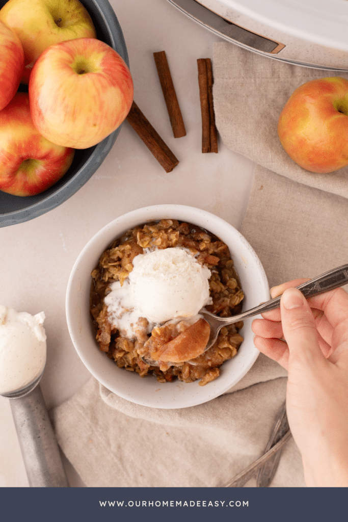 looking down at slow cooker apple crisp and vanilla ice cream