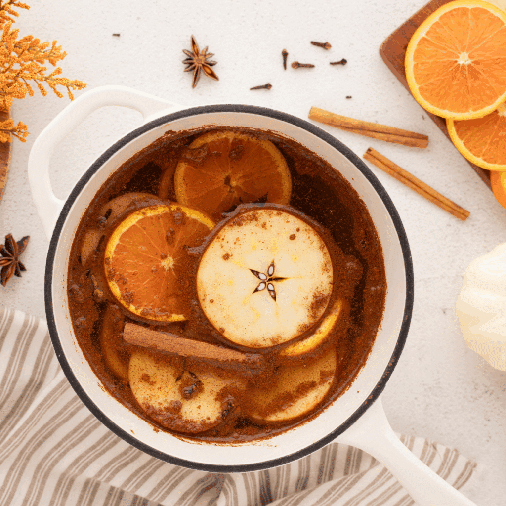 fall simmer pot on white countertop with sliced oranges