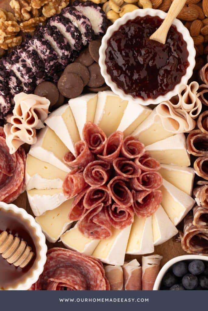 close up of cut brie with salami rolled up