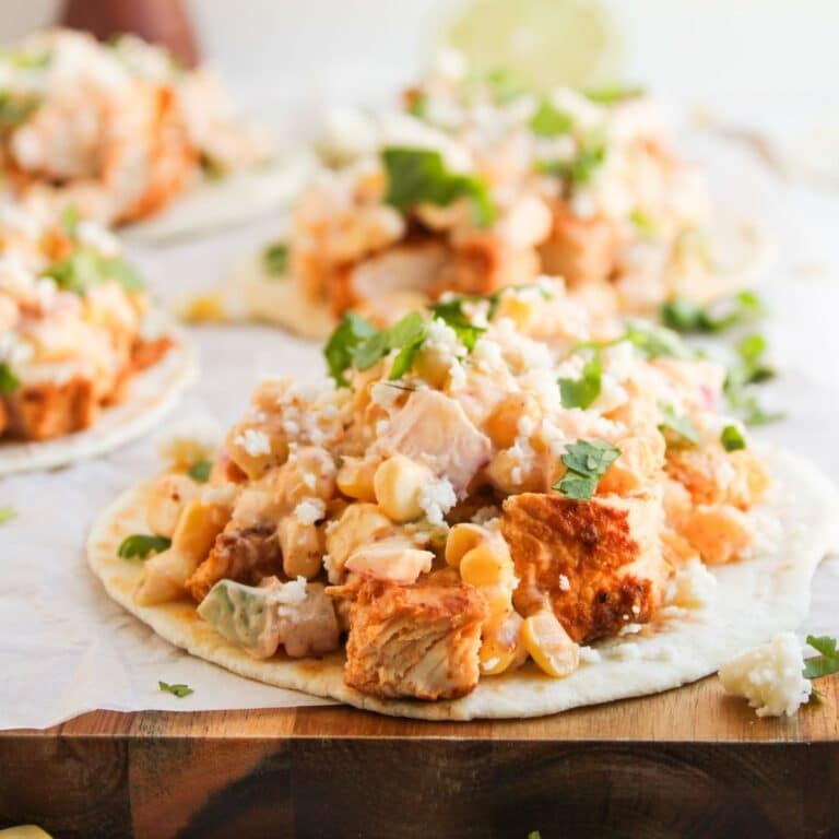 finished elote chicken taco on wooden cutting board