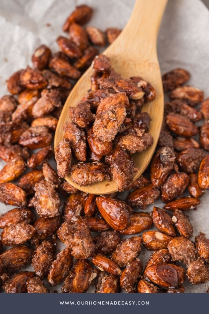 close up of candied almonds on wooden spoon