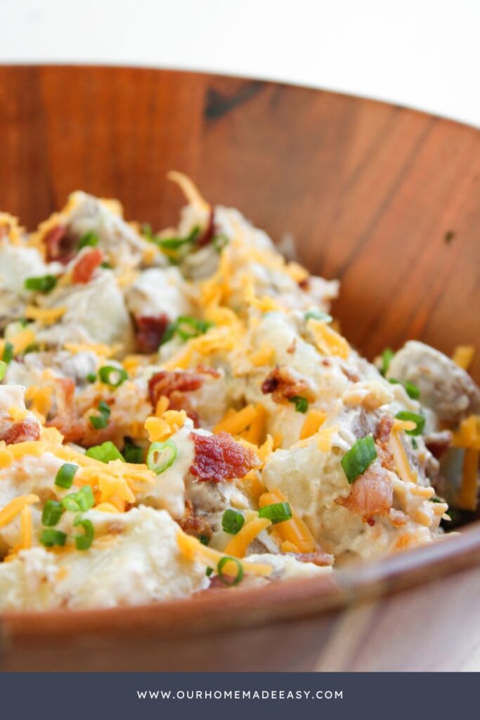 cheesy potato salad in wooden bowl