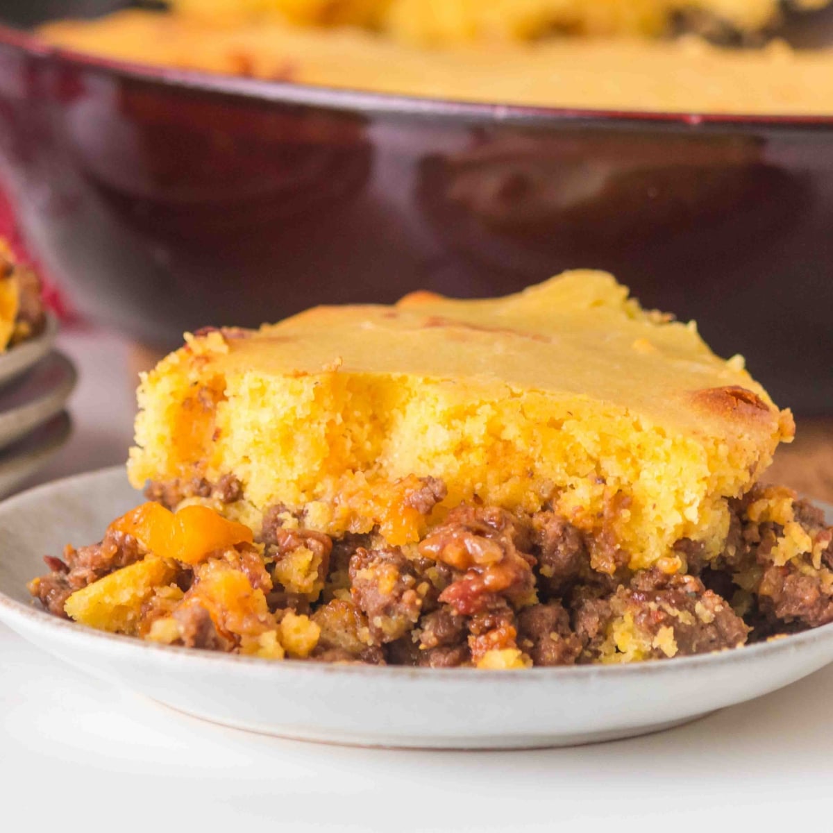 This Ground Beef Cornbread Casserole combines savory BBQ ground beef, crispy bacon, bell peppers, and a homemade cheesy cornbread topping.